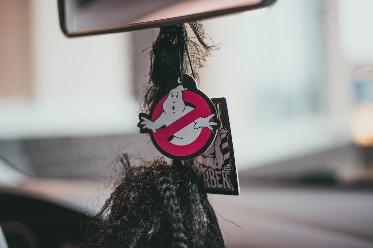 Hanging Ghostbusters themed air freshener inside a car, evoking humor and nostalgia.